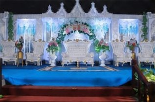 Pelaminan putih bergaya istana dengan karpet biru